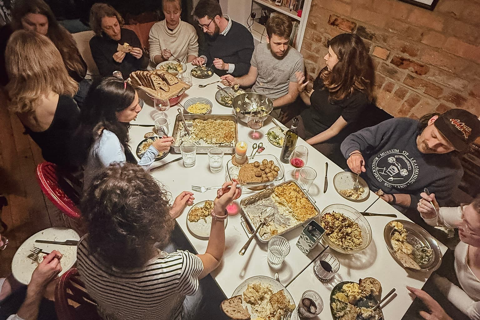 Guests enjoying a communal dinner at a long shared table